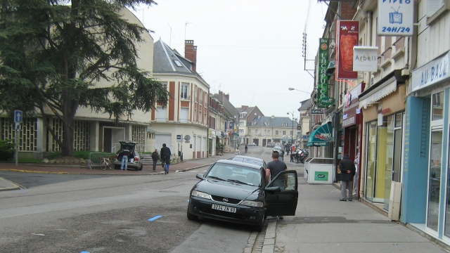 a french street with shops and wide road
